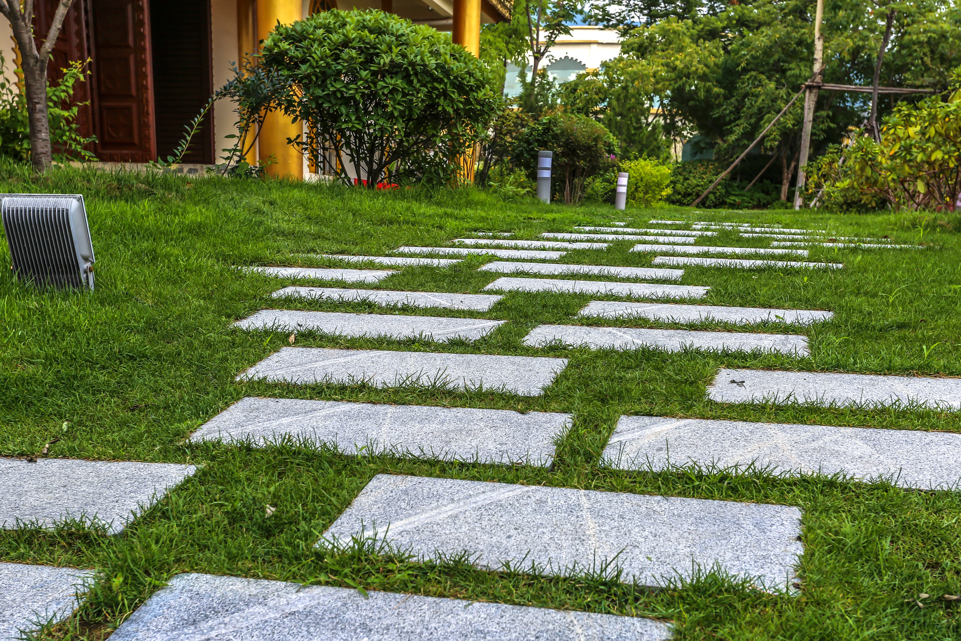 Fertige Naturstein-Terrasse aus Kalksteinplatten in Bad Homburg mit integrierter Gartenbeleuchtung und gepflegten Beeten im Außenbereich